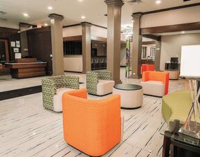 Lobby lounge with colorful seating, open space, and casual atmosphere at Wyndham Garden Williamsburg Busch Gardens Area.