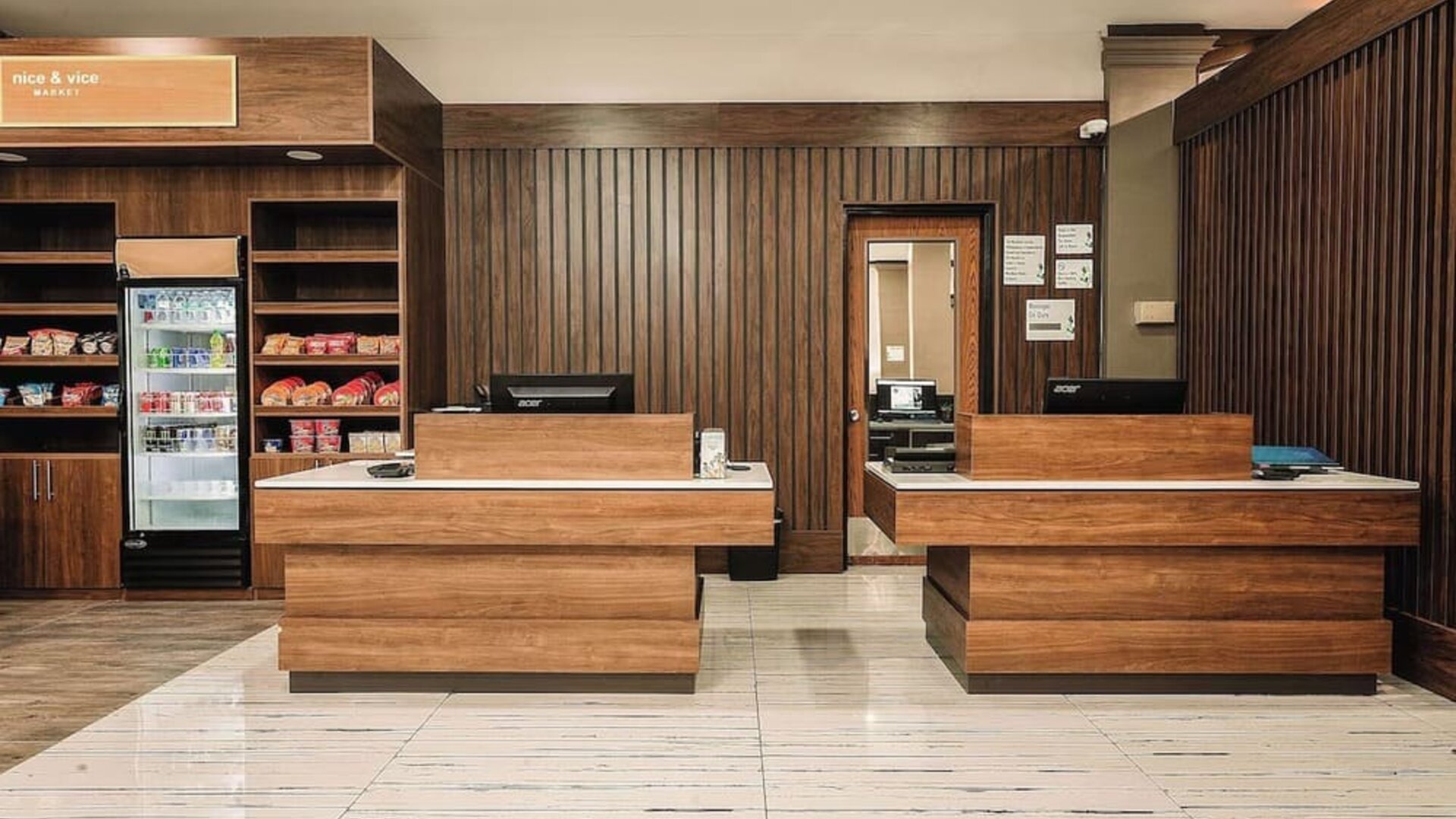 Reception desk area with wood finishes, snack station, and front desk service area at Wyndham Garden Williamsburg Busch Gardens Area.