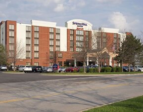 Exterior view of Marriott SpringHill Suites Naperville/Warrenville with red brick facade, covered entrance, and parked cars.