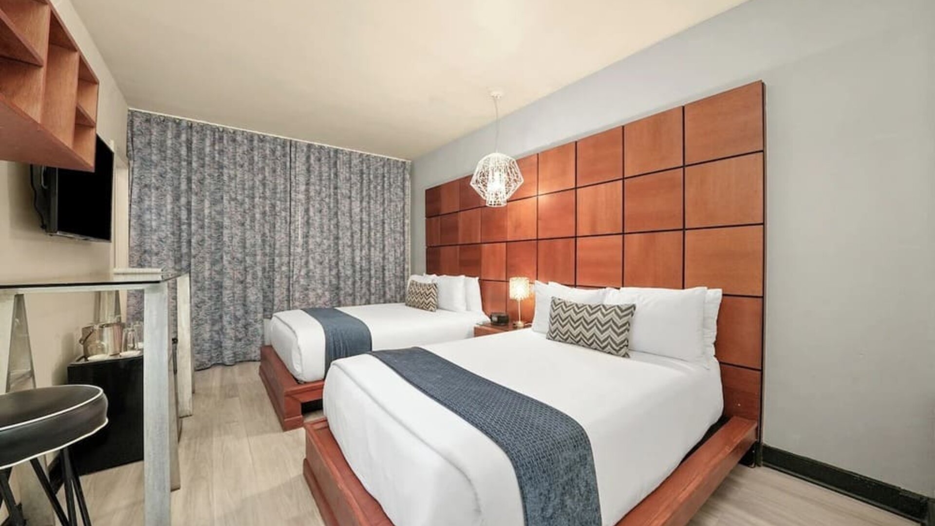 Double bed room with wood headboards, gray runners, workspace, and floor-length curtains at Chesterfield Hotel & Suites.