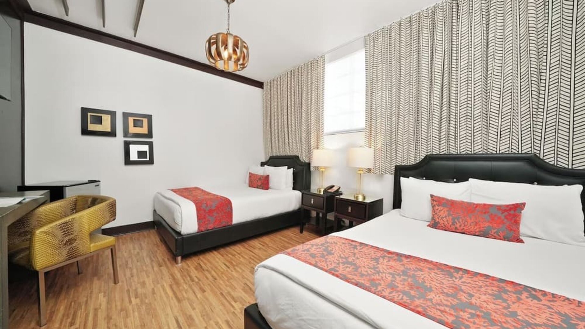 Guest room with two beds, patterned runners, bedside lamps, desk area, and wood flooring at Hotel Chelsea, A South Beach Group Hotel.