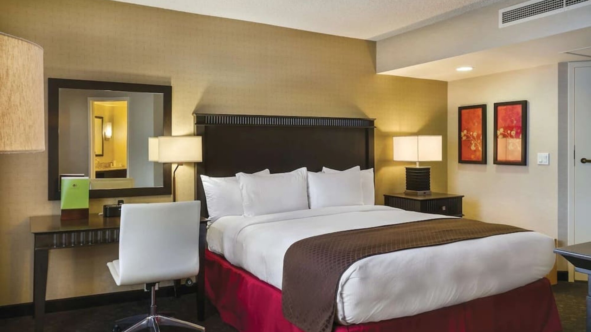 Guest room with king bed, desk area, bedside lamps, mirror, and warm-toned decor at DoubleTree By Hilton Los Angeles Downtown.