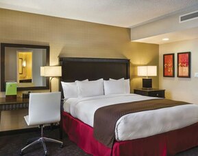 Guest room with king bed, desk area, bedside lamps, mirror, and warm-toned decor at DoubleTree By Hilton Los Angeles Downtown.