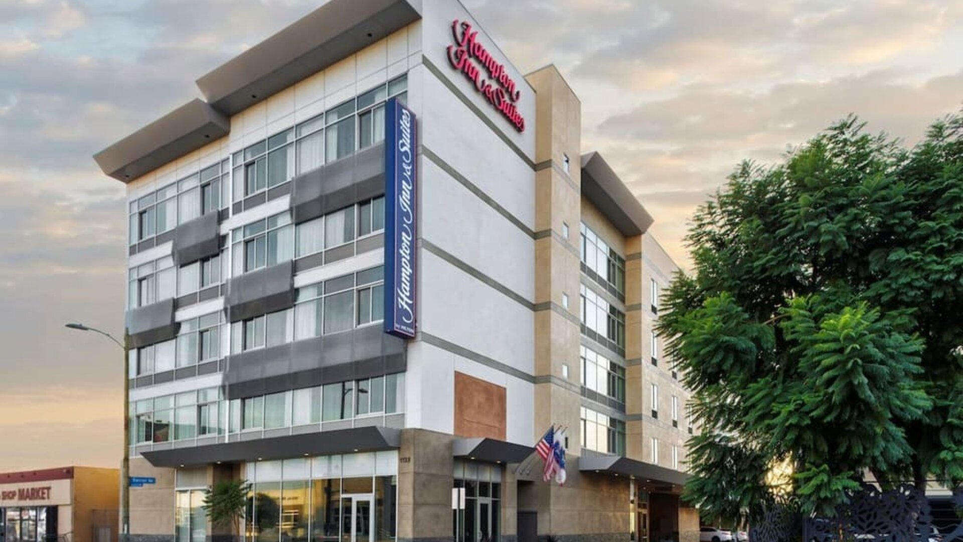 Exterior view of the hotel building with modern façade and signage at Hampton Inn & Suites Los Angeles / Hollywood.
