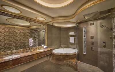 Large marble bathroom with soaking tub, glass shower, dual sinks, and decorative ceiling panels