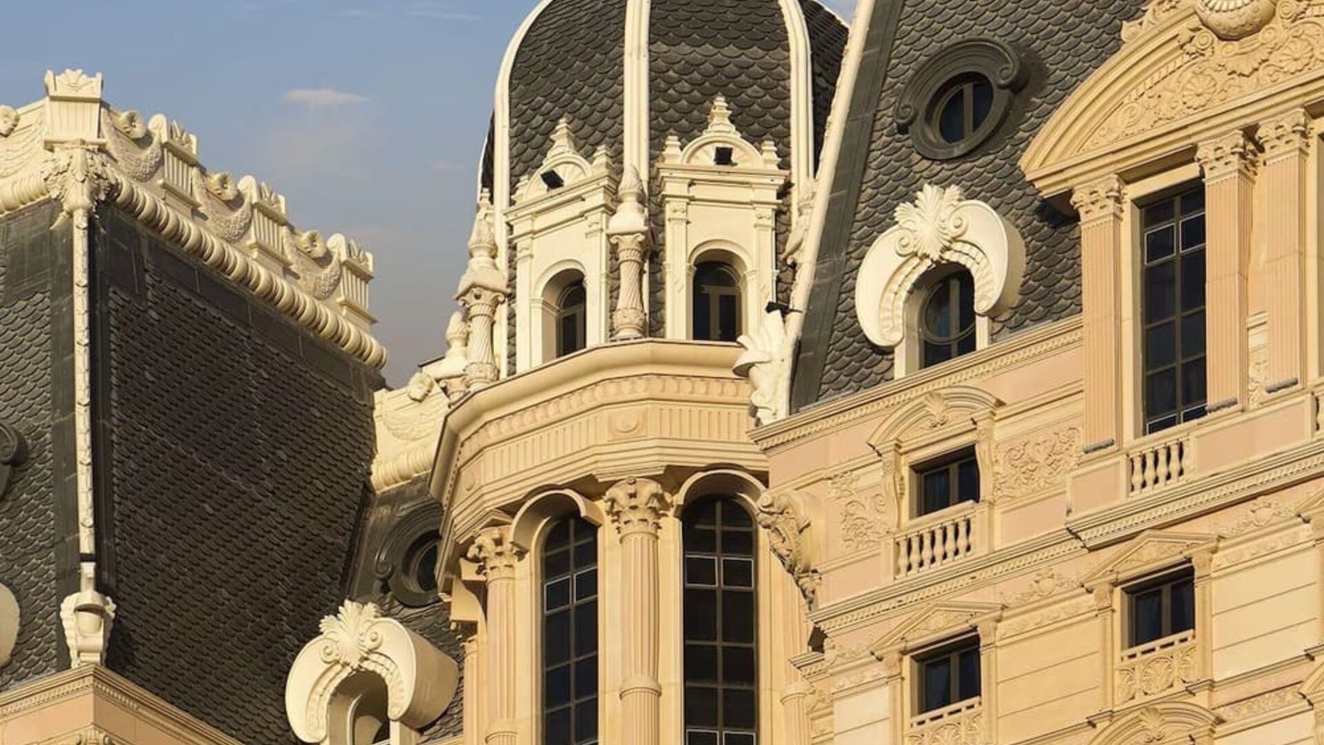 Close view of ornate building façade featuring domed roof, decorative moldings, and tall windows