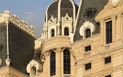 Close view of ornate building façade featuring domed roof, decorative moldings, and tall windows