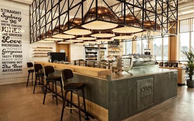 Stylish café bar with high stools, espresso machine, pendant lighting, and warm wood and metal finishes