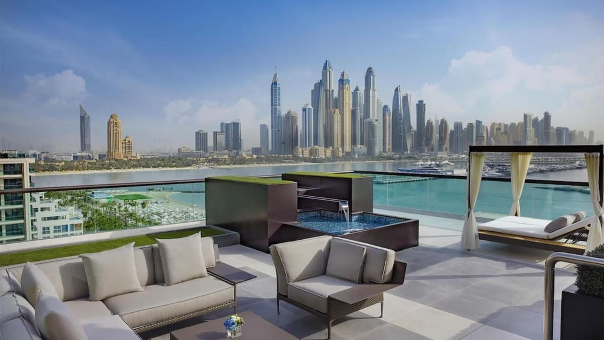Rooftop lounge with seating, small plunge pool, cabana daybeds, and panoramic skyline views