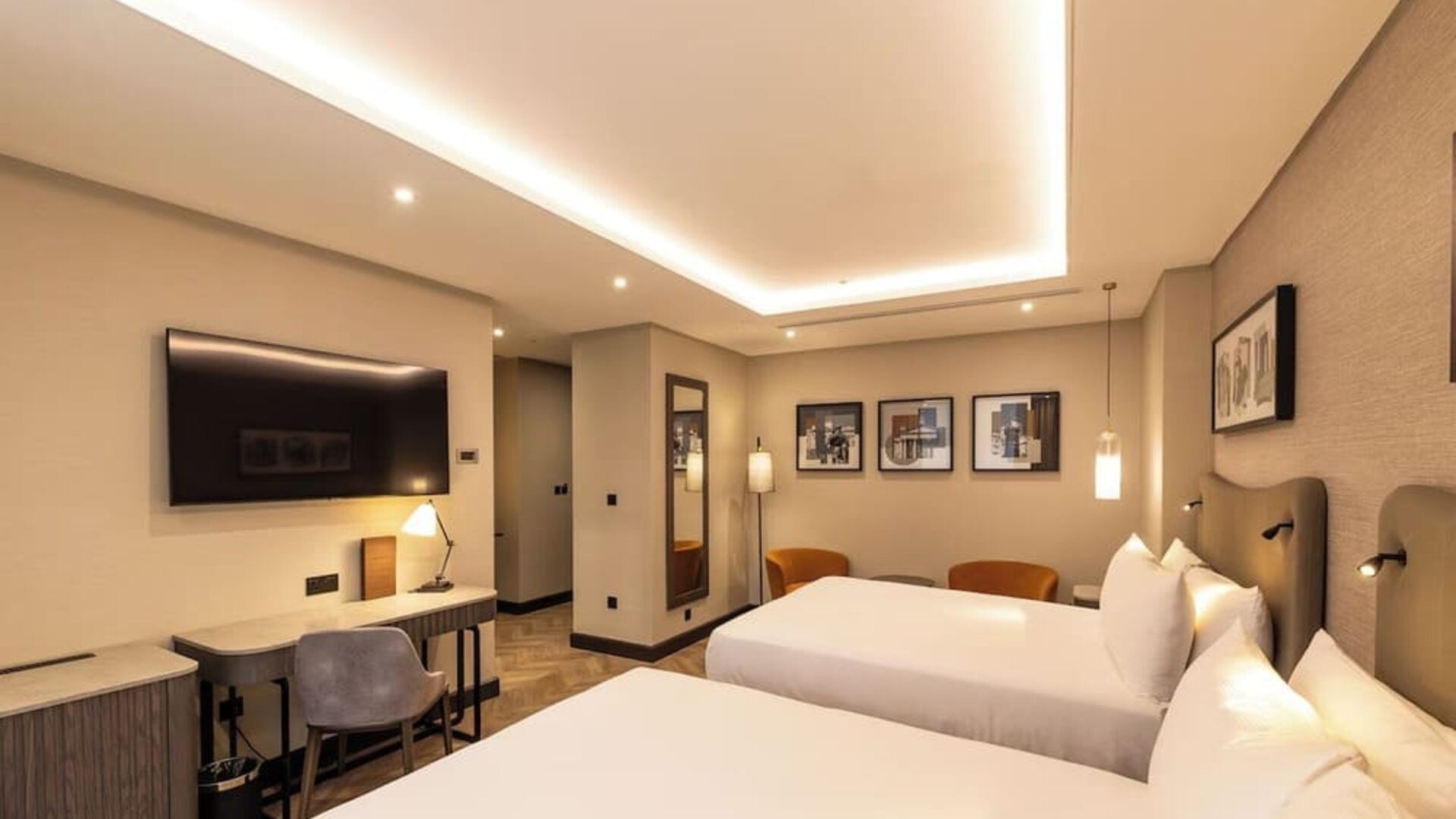 Contemporary room with two queen beds, wood flooring, framed artwork, and recessed ceiling lights