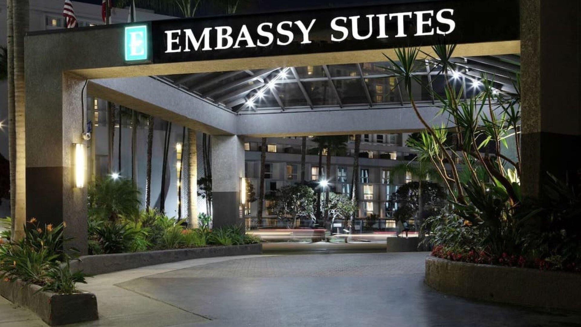 Nighttime front entrance with illuminated Embassy Suites signage and landscaped driveway at Embassy Suites By Hilton LAX Airport North.