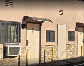 Exterior close-up of guest room entrances with private doors and outdoor corridor at Mid City Inn - Los Angeles.