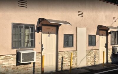 Exterior close-up of guest room entrances with private doors and outdoor corridor at Mid City Inn - Los Angeles.