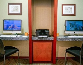 Business center with two desktop computers, printer station, and granite work counters at Shade Hotel Manhattan Beach.
