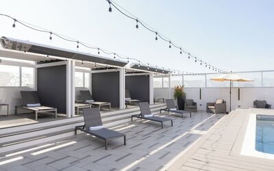 Rooftop pool deck with shaded cabanas, lounge chairs, and string lighting at Shade Hotel Manhattan Beach.