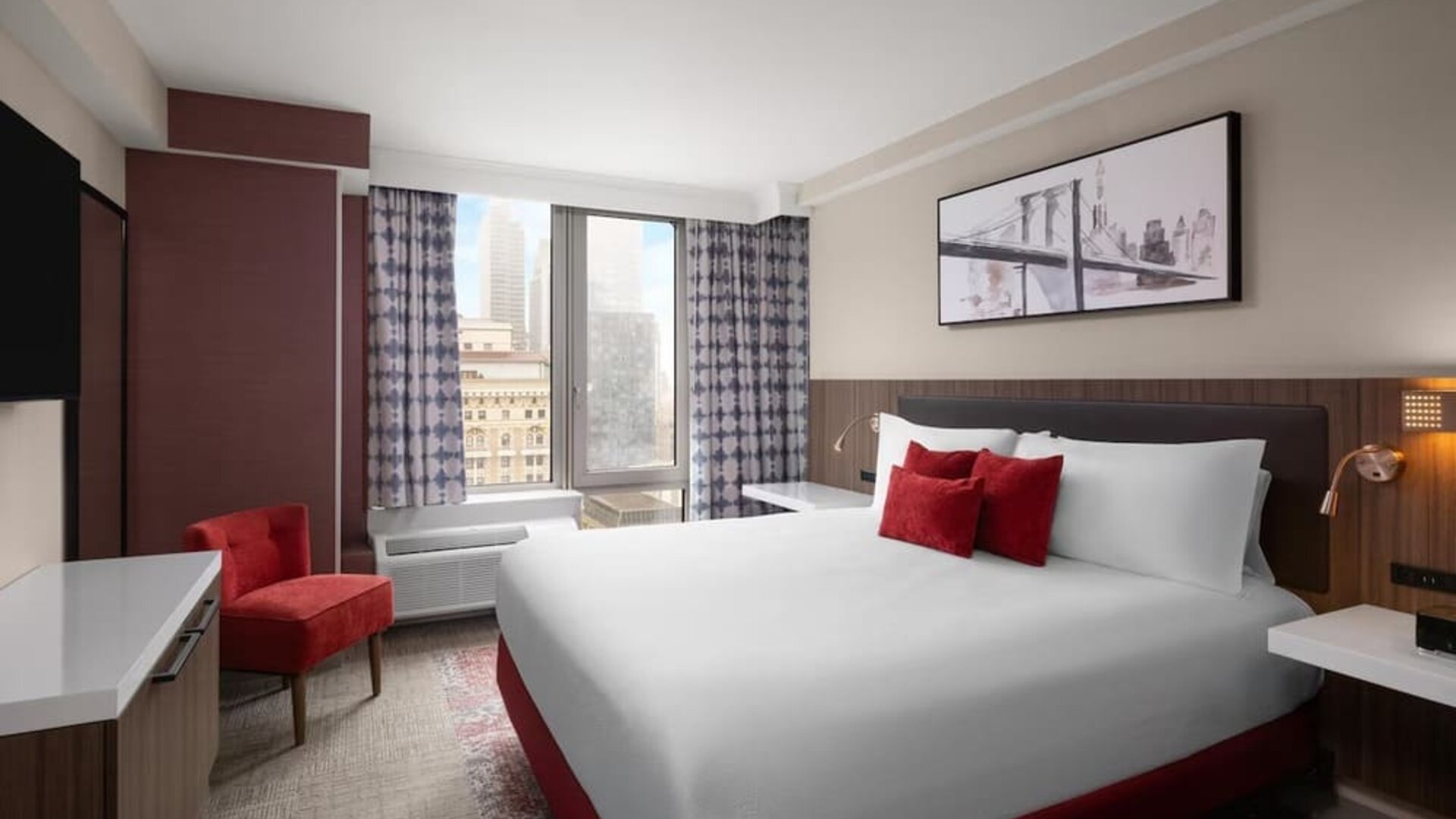 Spacious king guest room with red accents at Hilton Garden Inn New York/West 35th Street.