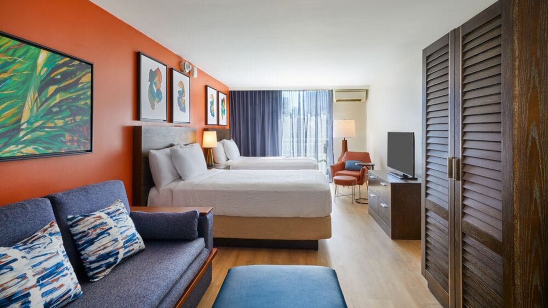 Spacious studio-style guest room with two beds and seating area at Courtyard Waikiki Beach.
