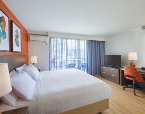 Modern king guest room with workspace and balcony at Courtyard Waikiki Beach.