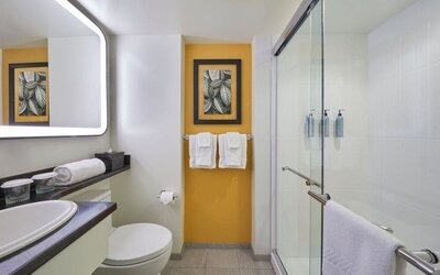 Modern bathroom with walk-in shower at Courtyard Waikiki Beach.