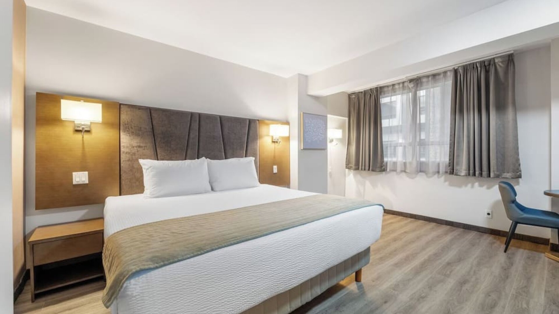 Bright king bedroom with comfortable bedding and workspace at Hotel Montreal Metropolitan, An Ascend Collection Hotel.
