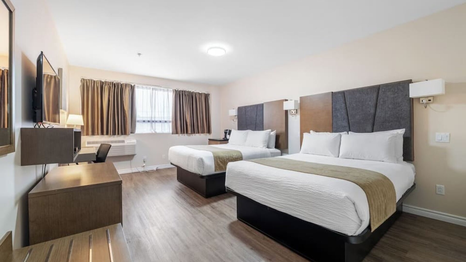 Double queen guest room with stylish finishes and workspace at Hotel Montreal Metropolitan, An Ascend Collection Hotel.
