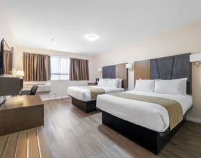 Double queen guest room with stylish finishes and workspace at Hotel Montreal Metropolitan, An Ascend Collection Hotel.