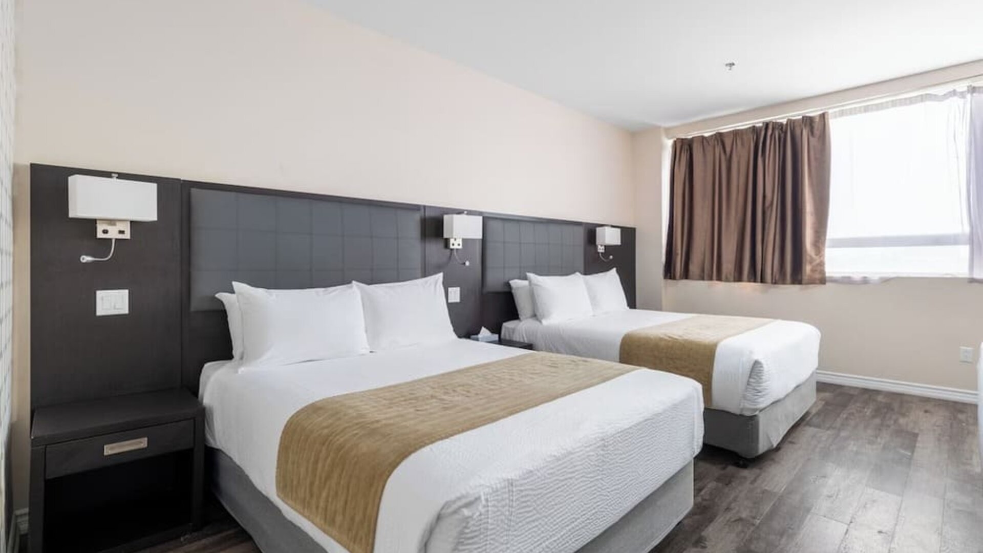Double queen guest room with modern furnishings and natural light at Hotel Montreal Metropolitan, An Ascend Collection Hotel.