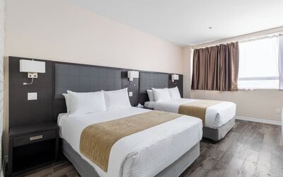 Double queen guest room with modern furnishings and natural light at Hotel Montreal Metropolitan, An Ascend Collection Hotel.
