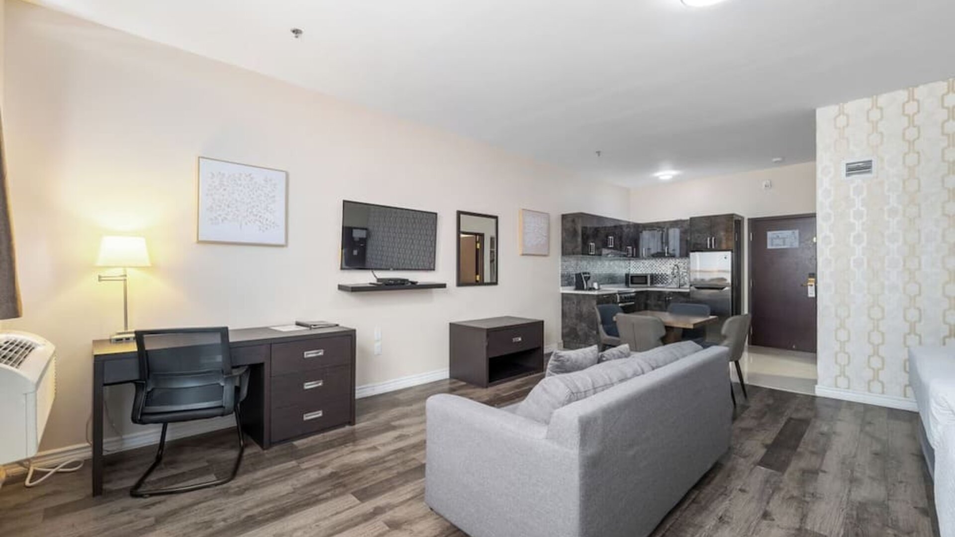 Spacious suite with living room, dining area, and full kitchenette at Hotel Montreal Metropolitan, An Ascend Collection Hotel.