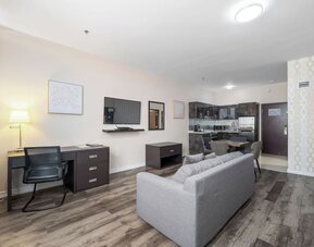 Spacious suite with living room, dining area, and full kitchenette at Hotel Montreal Metropolitan, An Ascend Collection Hotel.