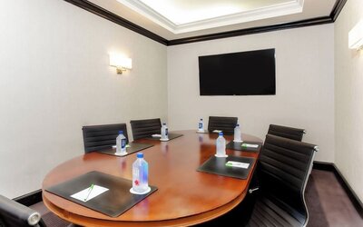 Private meeting room with conference table and presentation screen at Courtyard By Marriott New York JFK Airport.