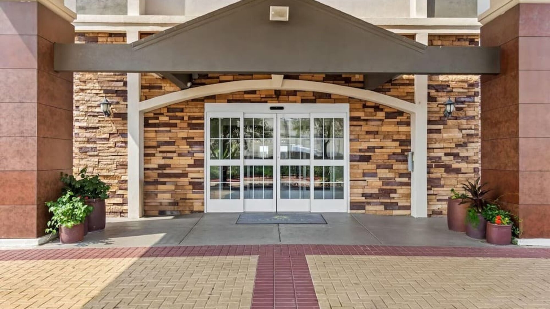 Front entrance with covered drop-off area at La Quinta Inn & Suites By Wyndham Houston Energy Corridor.