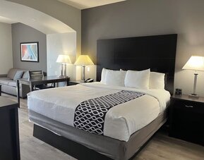 Guest room with seating area and workspace at La Quinta Inn & Suites By Wyndham Houston Energy Corridor.