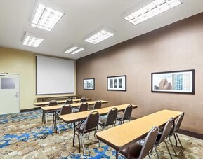 Meeting room with classroom-style seating and presentation screen at La Quinta Inn & Suites By Wyndham Houston Energy Corridor.