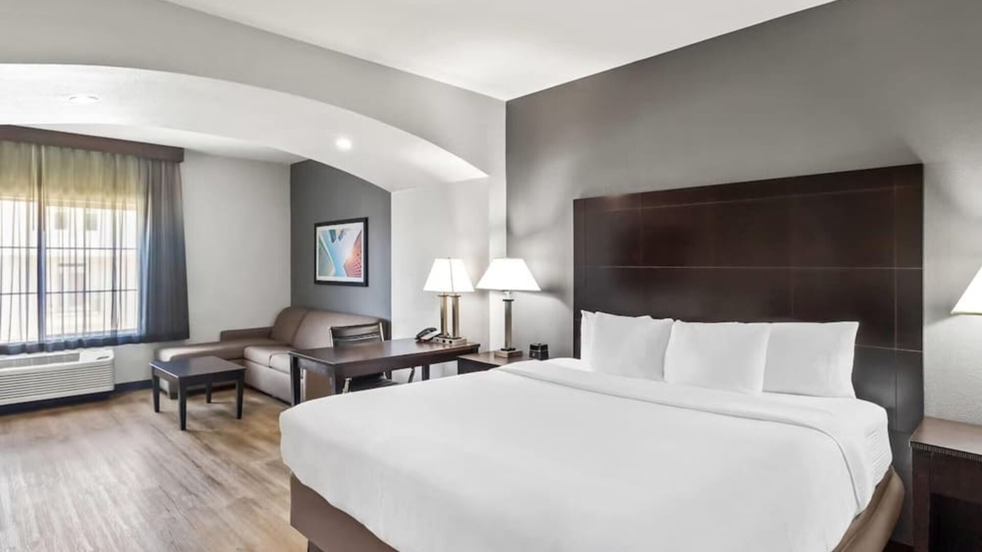 Spacious guest suite with king bed and lounge area at La Quinta Inn & Suites By Wyndham Houston Energy Corridor.