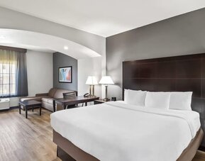 Spacious guest suite with king bed and lounge area at La Quinta Inn & Suites By Wyndham Houston Energy Corridor.