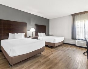 Guest room with two beds and workspace at La Quinta Inn & Suites By Wyndham Houston Energy Corridor.