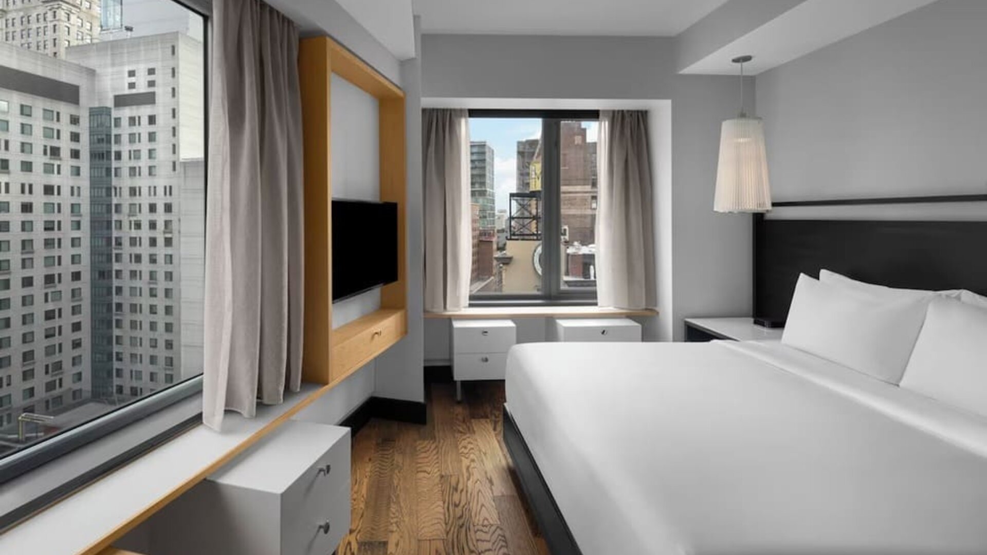 Stylish king guest room with minimalist furnishings and city skyline views at Hyatt Union Square New York.