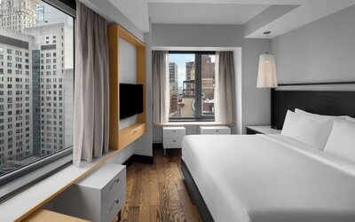 Stylish king guest room with minimalist furnishings and city skyline views at Hyatt Union Square New York.