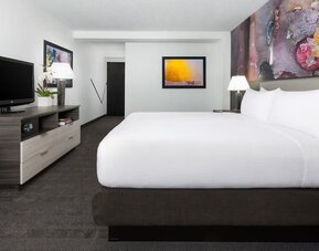 Spacious king guest room with modern furnishings and abstract artwork at Hotel Studio Allston.