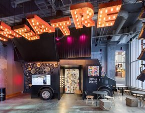 Colorful lobby lounge with neon ceiling lights and floor-to-ceiling windows at Moxy Boston Downtown.
