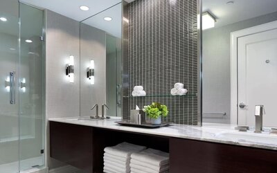 Modern hotel bathroom with marble vanity, glass walk-in shower, and contemporary lighting at Hyatt Regency Boston.