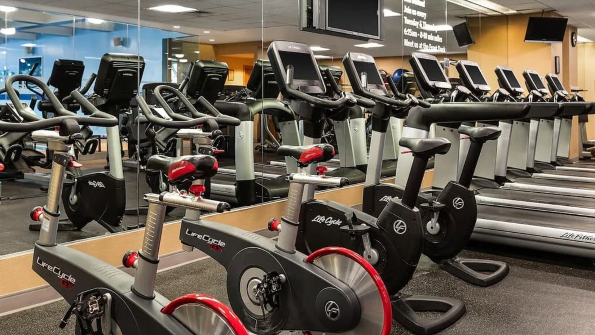 Fully equipped fitness center with treadmills, stationary bikes, and mirrored walls at Hyatt Regency Boston.