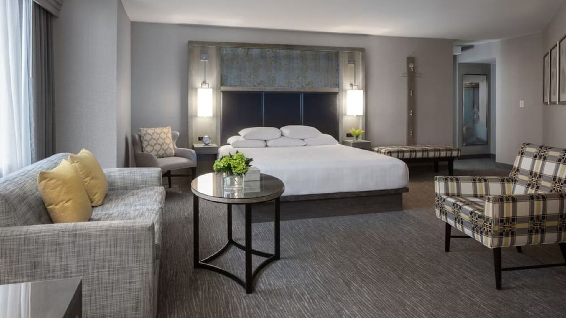 Spacious king guest room with sitting area, modern furnishings, and city-view windows at Hyatt Regency Boston.