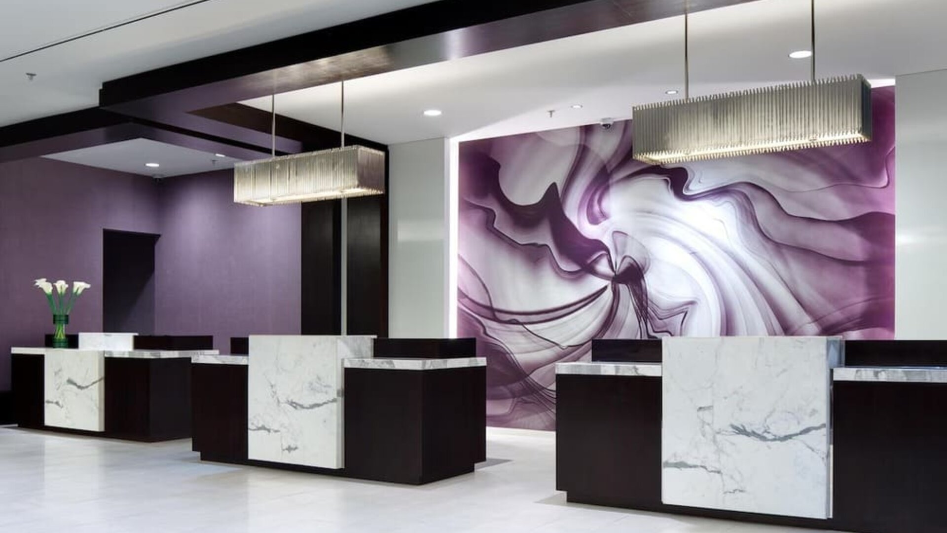 Modern hotel reception area with marble-front desks and purple accent wall at Hyatt Regency Boston.