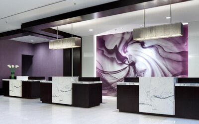 Modern hotel reception area with marble-front desks and purple accent wall at Hyatt Regency Boston.