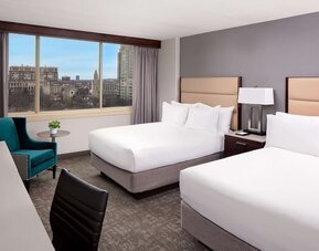 Spacious double queen guest room with large windows, city views, and modern furnishings at Hyatt Regency Boston/Cambridge.