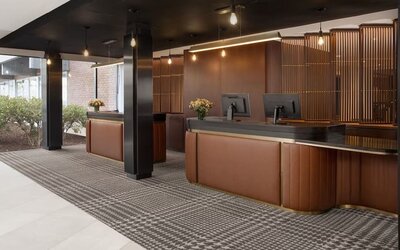 Modern hotel reception desk area with warm wood finishes and contemporary lighting at Hyatt Regency Boston/Cambridge.