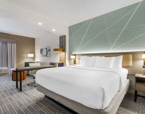 Spacious king suite with dedicated workspace, lounge seating, and modern furnishings at Comfort Inn & Suites Port Charlotte-Punta Gorda.