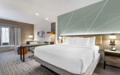 Spacious king suite with dedicated workspace, lounge seating, and modern furnishings at Comfort Inn & Suites Port Charlotte-Punta Gorda.